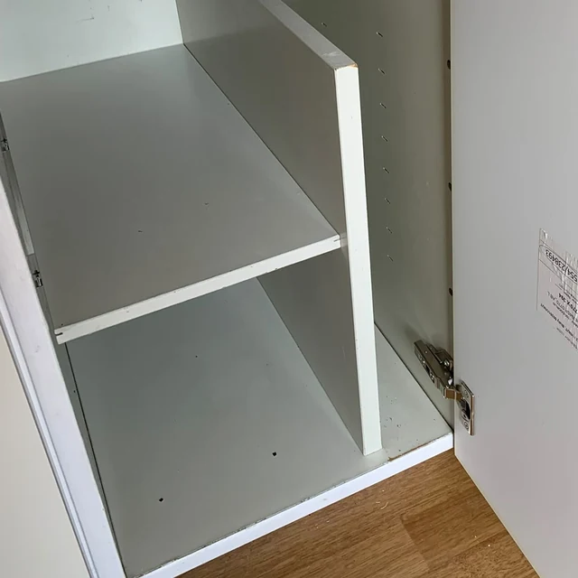 Samma köksskåp efter flyttstädningen, med ren hylla och botten