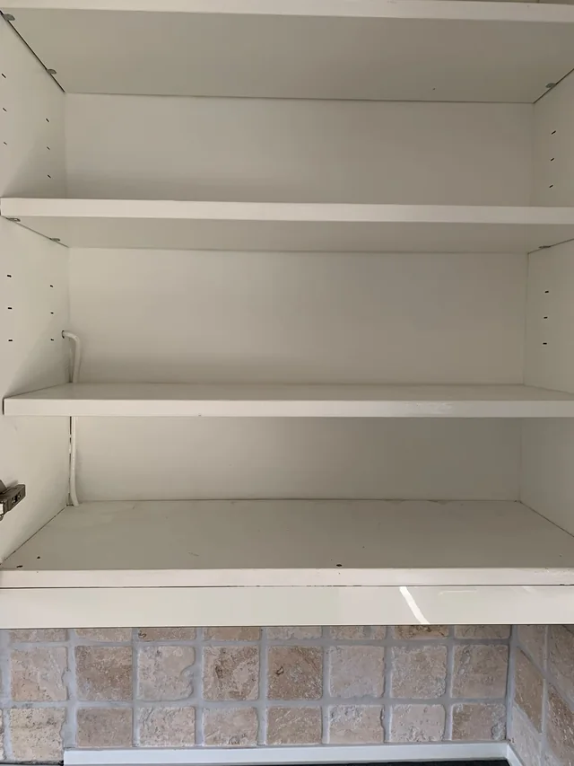 Ännu ett tömt köksskåp med hyllor i bostaden i Hägersten