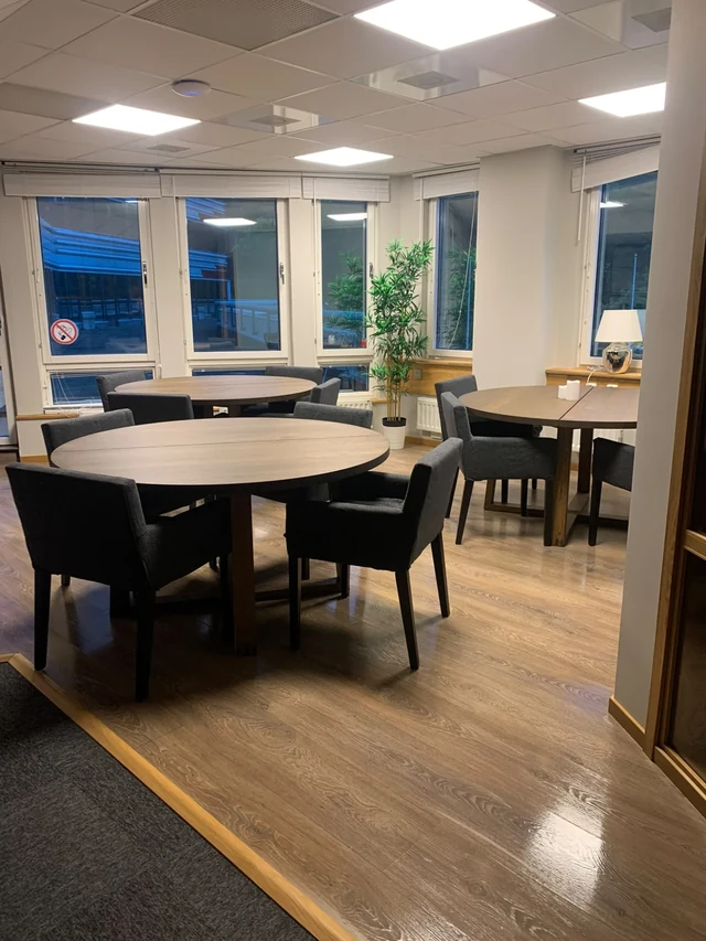 Runda träbord med stolar i lunchrummet på Novelias kontor