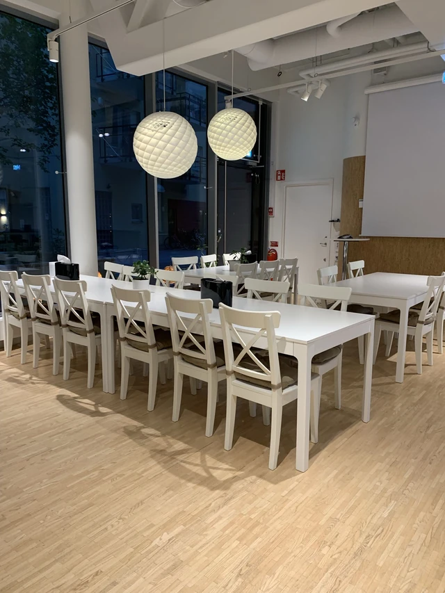 Långbord med vita stolar i Talenoms matsal